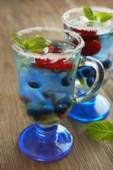 Glasses of berries juice on wooden table, closeup