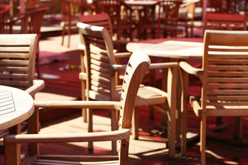 Fototapeta na wymiar Wooden chairs and tables on summer restaurant terrace