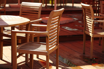 Wooden chairs and tables on summer restaurant terrace