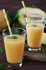Glasses of melon cocktail on wooden background
