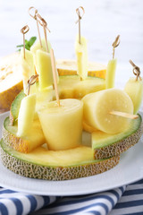 Melon ice lolly on white wooden background