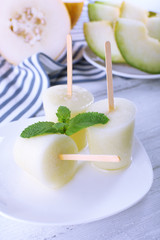 Melon ice lolly on table, closeup