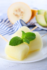 Melon ice lolly on wooden table, closeup