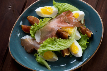 Salad with ham, fresh figs and eggs. Close-up, top view