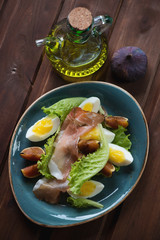 Salad with fig fruits, ham and eggs, studio shot, above view