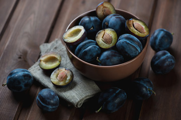 Closeup of ripe plums in a bowl, selective focus, studio shot