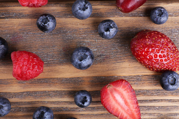 Tasty ripe berries on wooden table close up