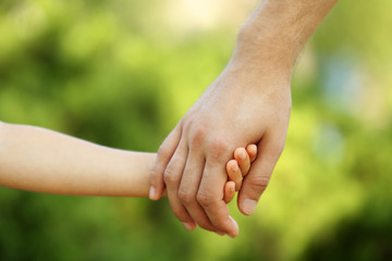 Father and daughter hands outdoors