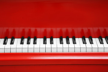 Piano keys of red piano close up