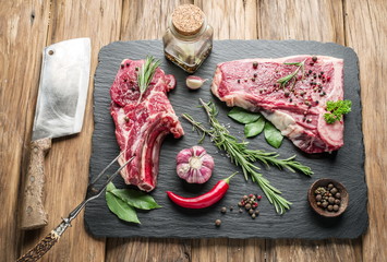 Raw beef steaks with spices on a white background.