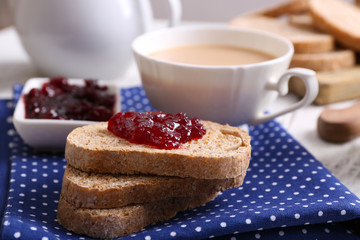 Fresh toast with jam and cup of coffee on table close up