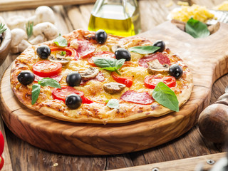 Pizza with mushrooms, salami and tomatoes.