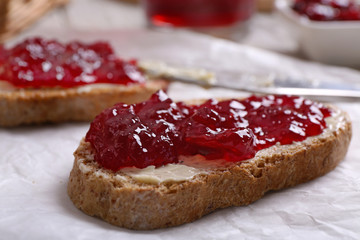 Fresh toast with butter and jam on table close up