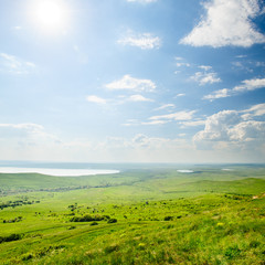 Fototapeta na wymiar Photo of beautiful landscape with grassy and land lake under sunny skies