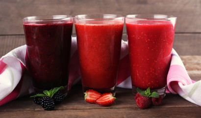 Berry cocktails and berries and napkin on wooden background