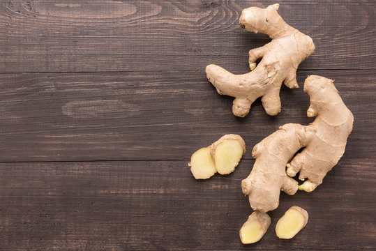Ginger root on the wooden background. Top view