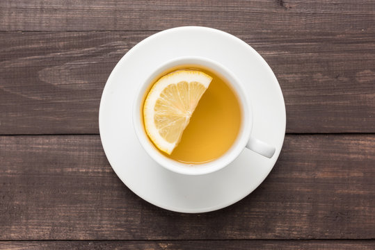 Ginger tea with lemon on the wooden background