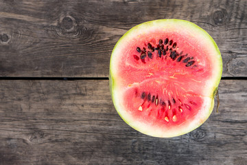 Fototapeta na wymiar Cut in half watermelon on old wooden table