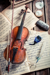 Retro violin and musical sheets on old wooden table