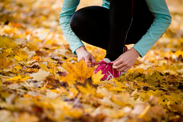 Woman tying shoelaces - jogging in nature