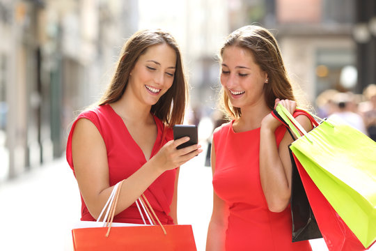 Two fashion shoppers shopping with a smart phone