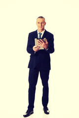 Full length mature man using digital tablet