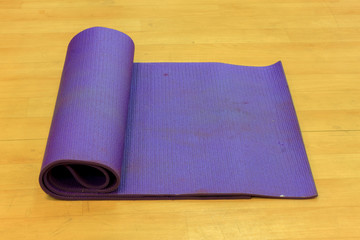 Yoga mat on wood background.