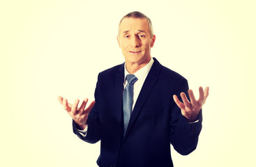 Businessman with open hands in undecided gesture