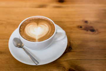 Hot art Latte Coffee in a cup on wooden table.