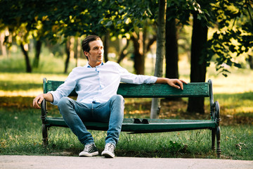 handsome adult man sitting on bench