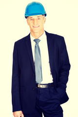 Businessman with hand in pocket wearing a helmet 