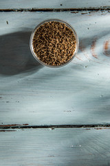 close up of a bowl of green aniseed, on wooden background