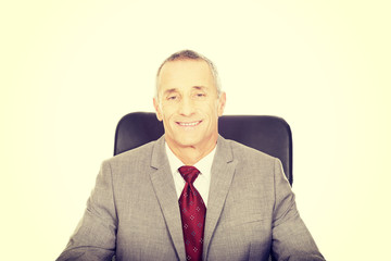 Smiling mature businessman sitting on armchair
