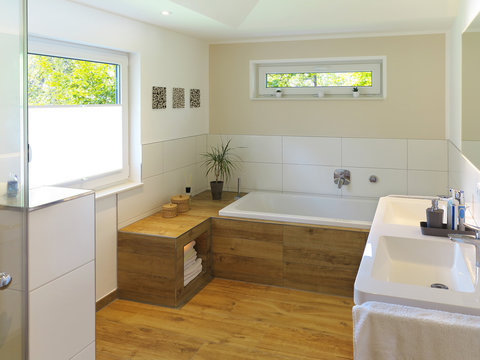 Modernes Badezimmer mit Badewanne, Waschbecken und Holzboden
