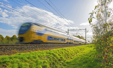 Naklejka premium Train driving towards the sun in autumn