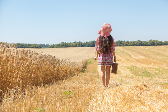 girl in hat on wheat field