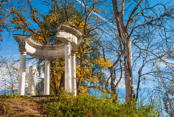 Autumn park with ancient rotunda on the hill