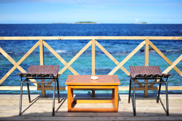 Outdoor Cafe bar on the wooden terrace with Blue ocean background, Maldives.