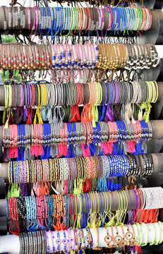 Colorful bracelets on display case in street jewelry store 