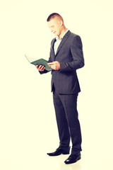 Young businessman reading his note book