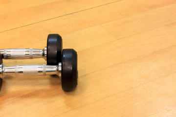 Dumbbells on the wood background.