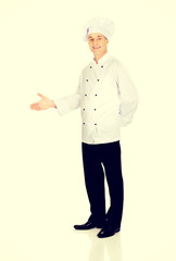 Happy mature chef with welcome gesture