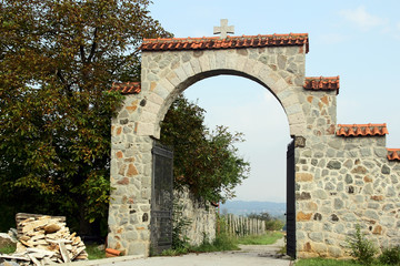 The stone wall and the gate in the monastery garden