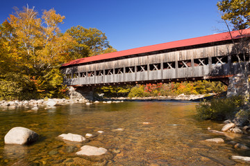 Fototapeta na wymiar Covered bridge, river and fall foliage, Swift River, NH, USA