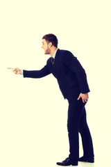 Angry businessman pointing to the left.
