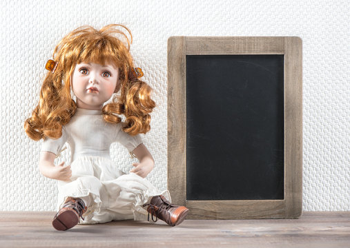 Vintage doll and chalkboard for your text. Retro style