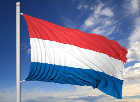Waving flag of Netherlands on flagpole, on blue sky background.