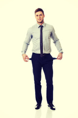 Businessman showing his empty pockets.