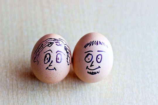 Painted easter eggs with man and woman smiling faces. Conceptual image with happy couple