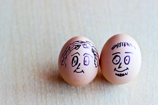 Painted easter eggs with man and woman smiling faces. Conceptual image with happy couple
